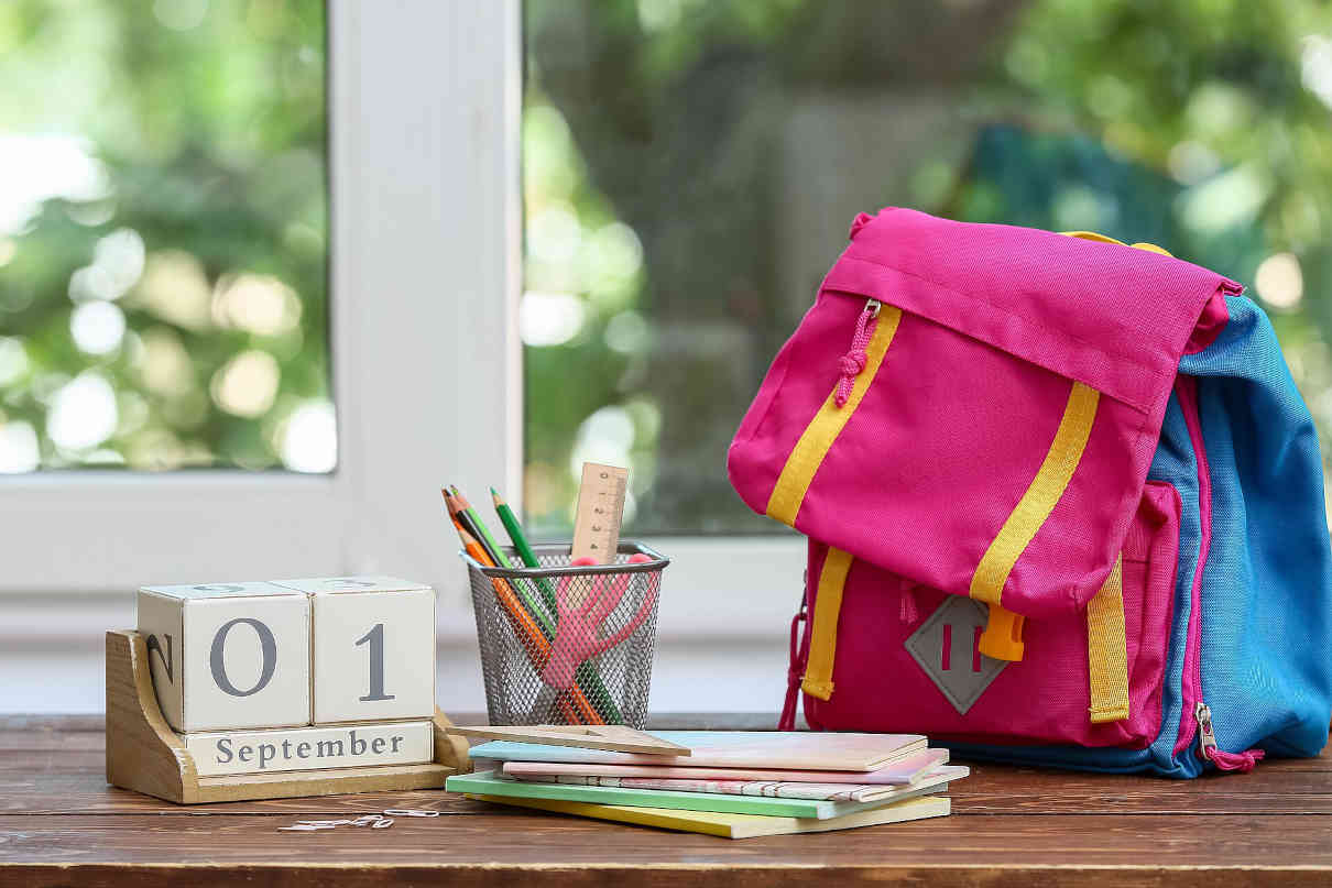 Ab wann Gymivorbereitung: Der Kalender auf dem Tisch mit Schulranzen zeigt, dass man auf den richtigen Zeitpunkt achten muss.
